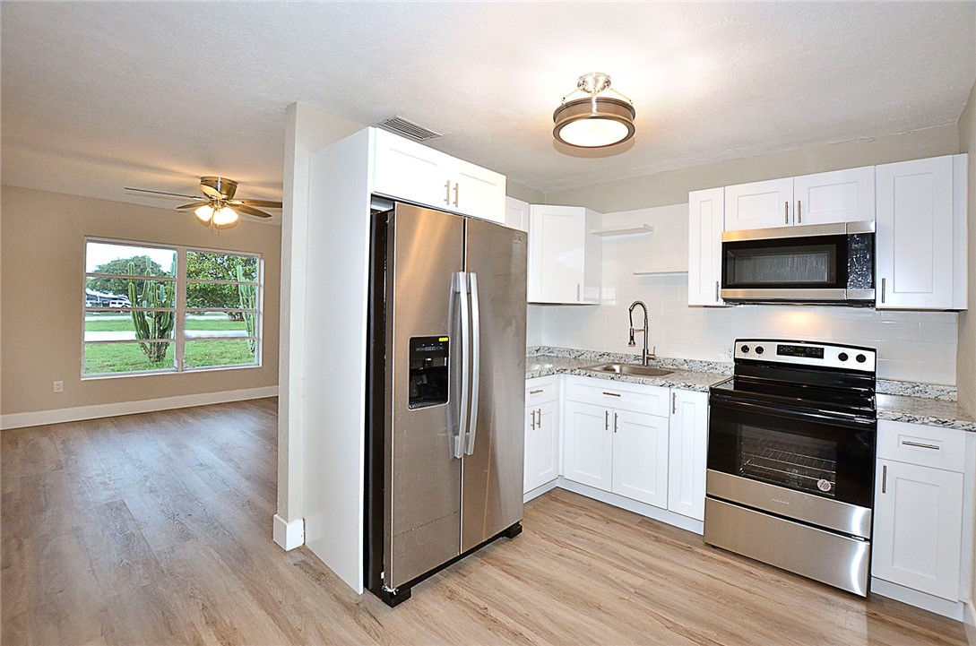 355 6th Road Southwest Vero Beach, FL 32962 - Photo 7 of 23 a kitchen with a refrigerator stove and wooden floor