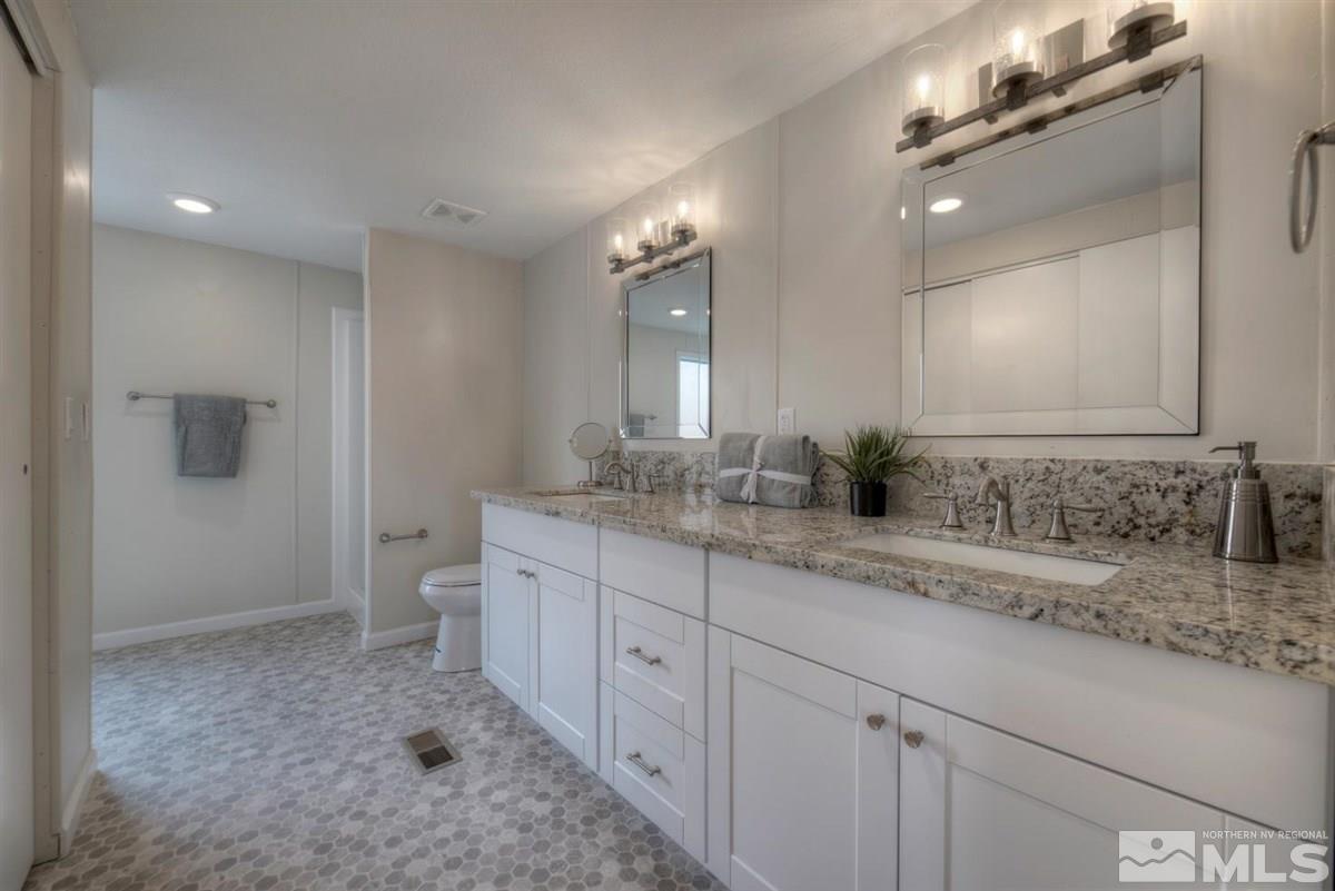 370 Scorpio Circle Reno, NV 89521 - Photo 13 of 25 a spacious bathroom with a granite countertop sink a toilet and a mirror