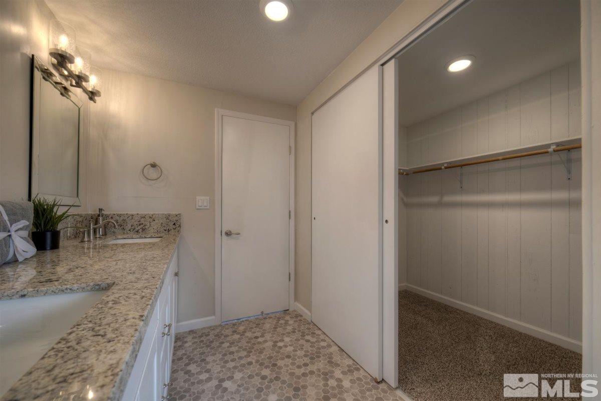 370 Scorpio Circle Reno, NV 89521 - Photo 14 of 25 a bathroom with a granite countertop sink a shower and a mirror