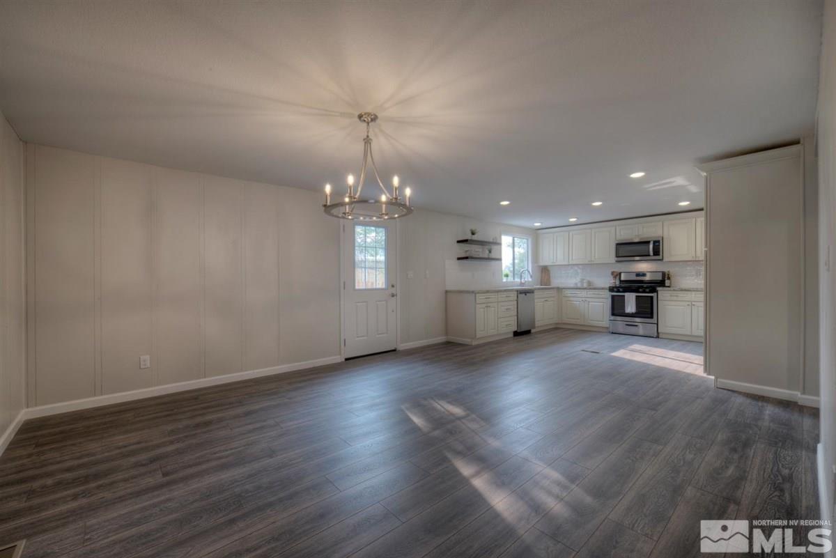 370 Scorpio Circle Reno, NV 89521 - Photo 6 of 25 an empty room with wooden floor kitchen appliances and windows