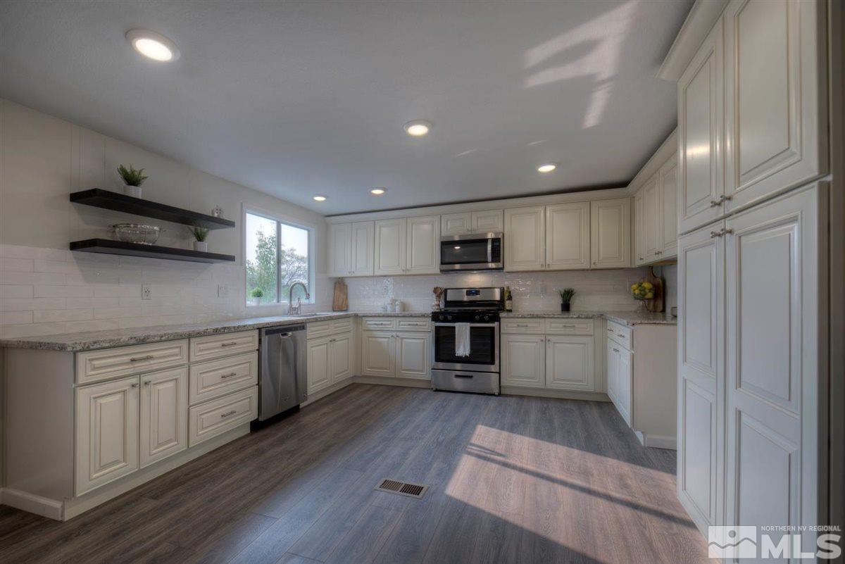 370 Scorpio Circle Reno, NV 89521 - Photo 7 of 25 a kitchen with white cabinets stainless steel appliances and sink
