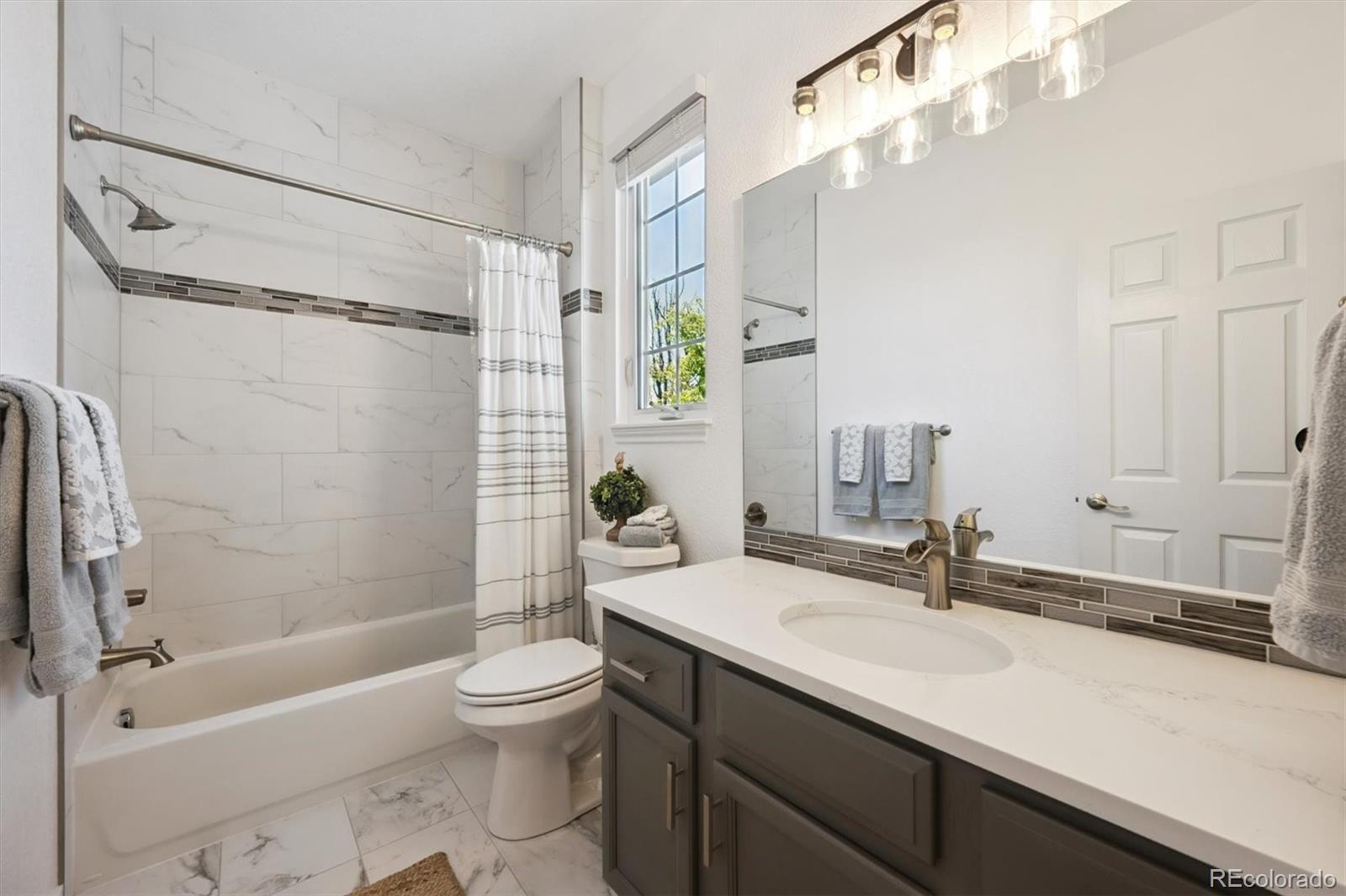 724 Imboden Road Watkins, CO 80137 - Photo 27 of 50 a bathroom with a sink a toilet and a large mirror