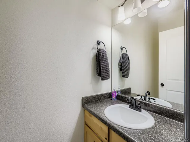 a bathroom with a granite countertop sink a mirror and vanity