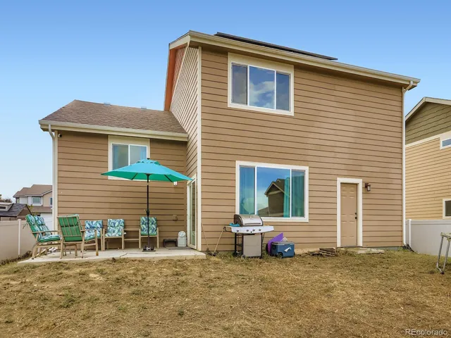 a view of a house with a patio and a yard