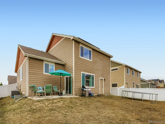 a backyard of a house with table and chairs