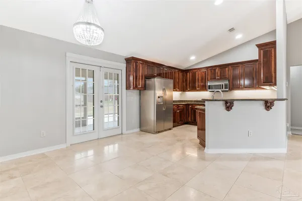 a kitchen with stainless steel appliances granite countertop a refrigerator and a stove top oven