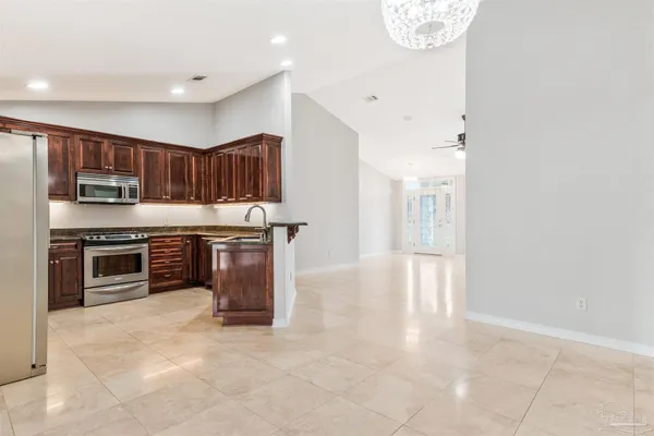 a kitchen with stainless steel appliances granite countertop a stove microwave and cabinets