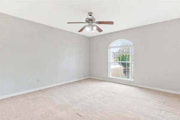 an empty room with a ceiling fan and a window