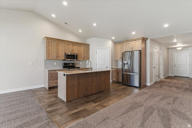 2028 West Grace Way Layton, UT 84041 - Photo 8 of 36 Kitchen with stainless steel appliances, decorative backsplash, wood finish floors, an island with sink, and recessed lighting