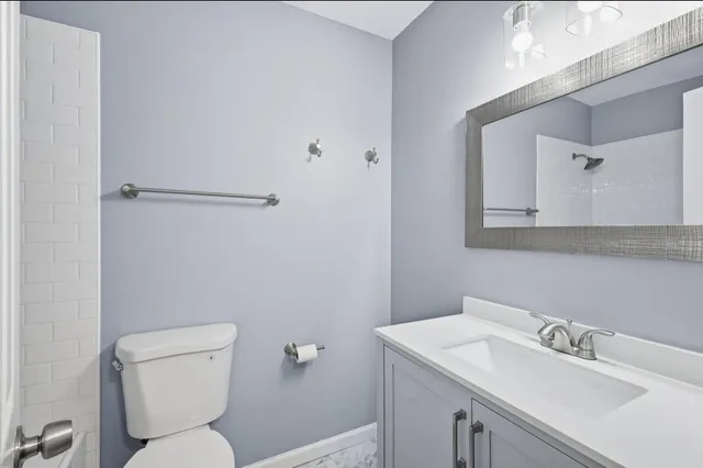a bathroom with a toilet sink and mirror