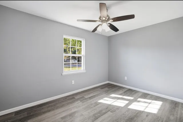 a view of a big room with wooden floor and windows