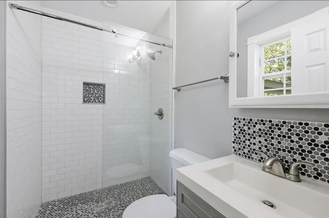 a bathroom with a sink a toilet and shower