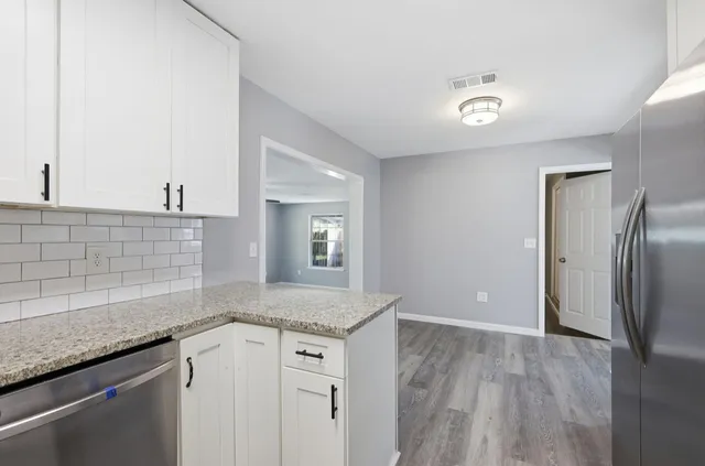 a kitchen with granite countertop a sink and refrigerator