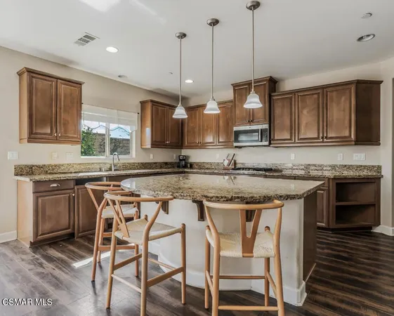 a kitchen with stainless steel appliances granite countertop a stove top oven a sink a counter space and cabinets