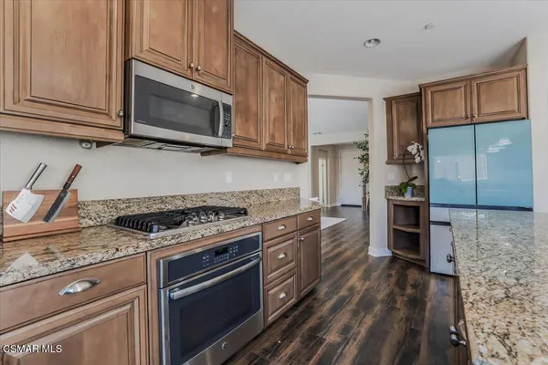 a kitchen with stainless steel appliances granite countertop a stove microwave and cabinets