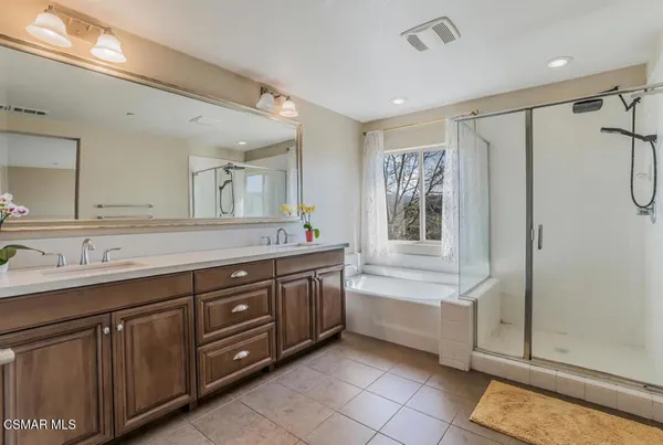a bathroom with a tub sink and mirror