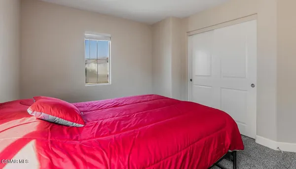 a bedroom with a bed and a painting on the wall