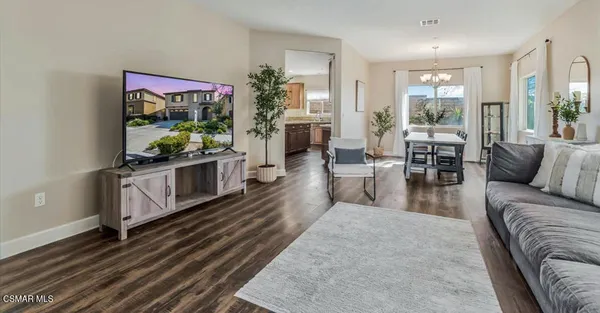 a living room with furniture a flat screen tv and a floor to ceiling window