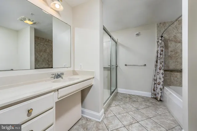 a bathroom with a granite countertop sink a mirror and shower