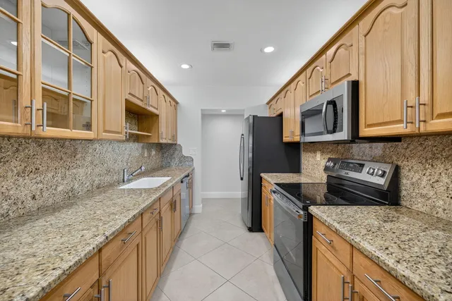 a kitchen with stainless steel appliances granite countertop a sink stove microwave and cabinets