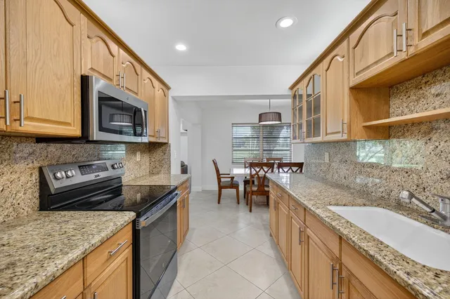 a kitchen with stainless steel appliances granite countertop a sink stove and microwave