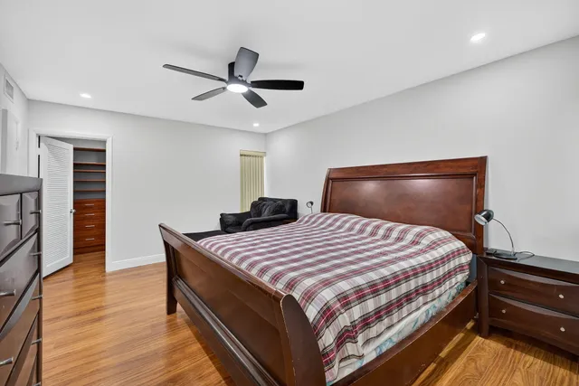 a bedroom with a bed and wooden floor