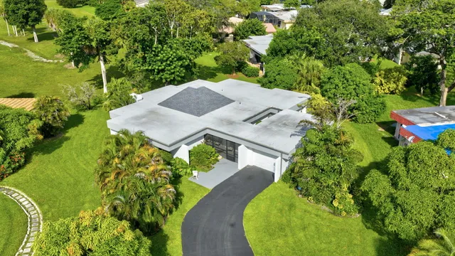 an aerial view of a house with swimming pool and garden