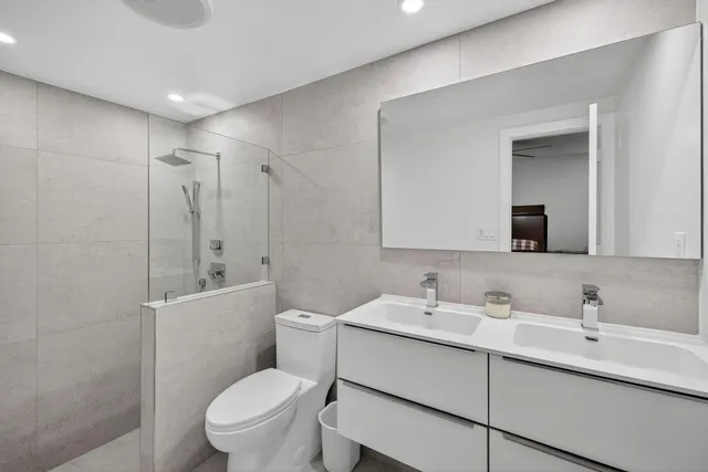 a bathroom with a sink toilet vanity and shower