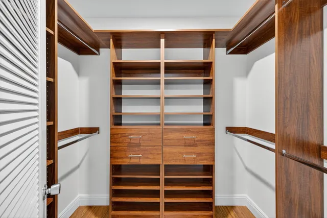 a view of walk in closet with empty racks