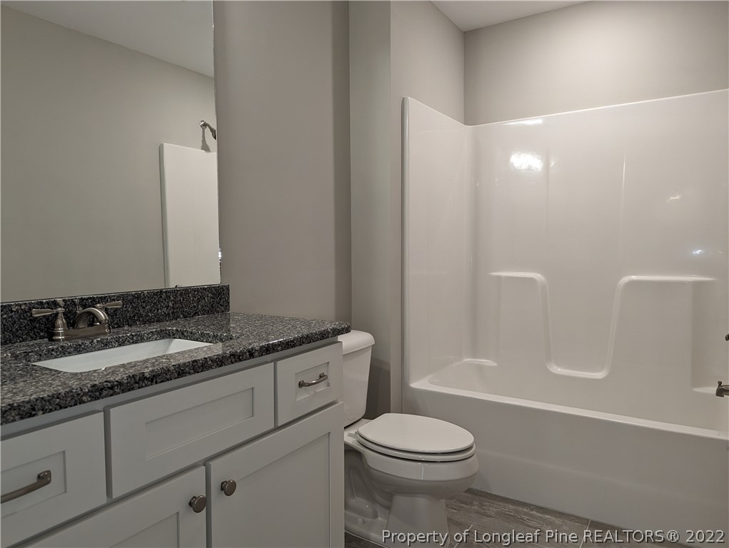 433 B & B Loop Road Raeford, NC 28376 - Photo 20 of 37 a bathroom with a granite countertop sink a toilet a mirror and bathtub