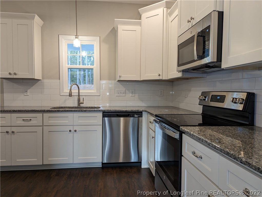 433 B & B Loop Road Raeford, NC 28376 - Photo 5 of 37 a kitchen with granite countertop white cabinets stainless steel appliances and a window