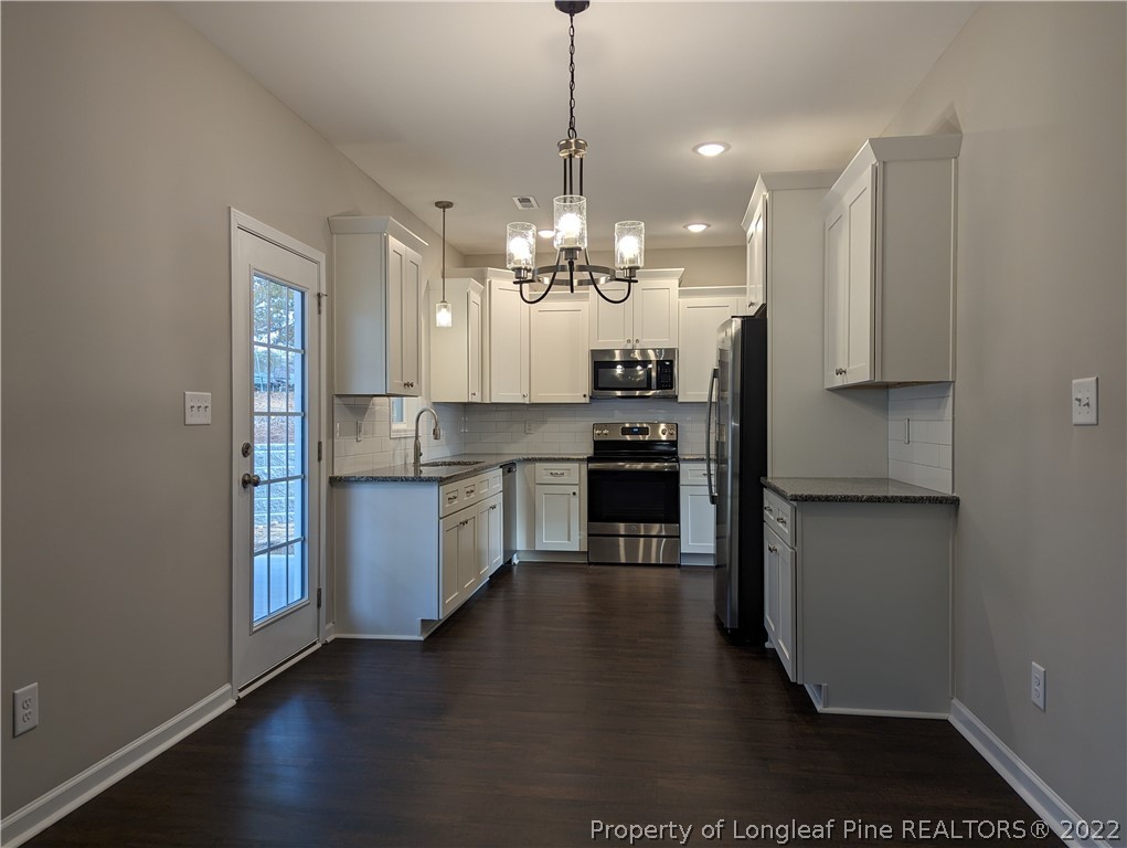 433 B & B Loop Road Raeford, NC 28376 - Photo 6 of 37 a kitchen with stainless steel appliances granite countertop a stove a sink and a refrigerator