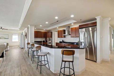 a kitchen with stainless steel appliances granite countertop a stove a sink and a refrigerator