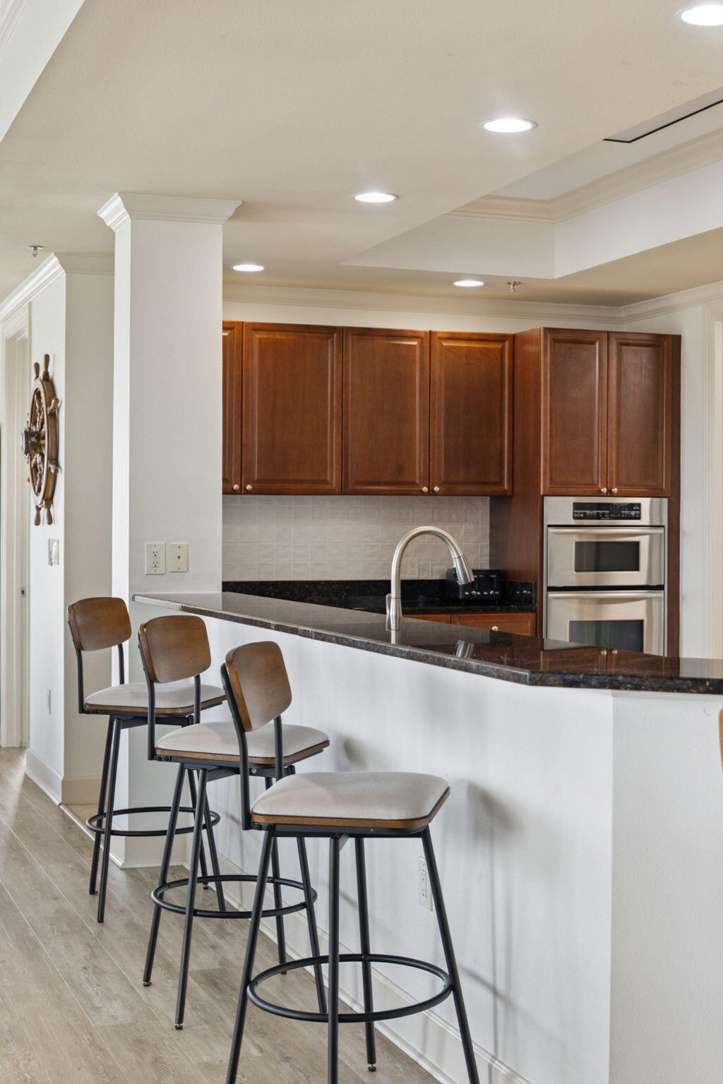 725 Gulf Shore Drive, Unit 902A Destin, FL 32541 - Photo 15 of 102 a kitchen with granite countertop a stove a sink and a refrigerator with wooden cabinets