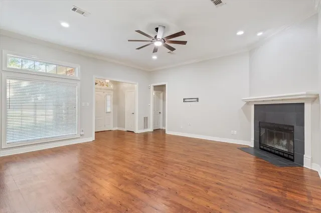 a view of an empty room with window and wooden floor