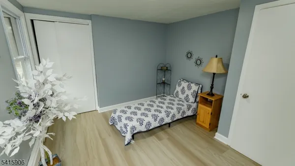 a bedroom with a bed and a wooden floor