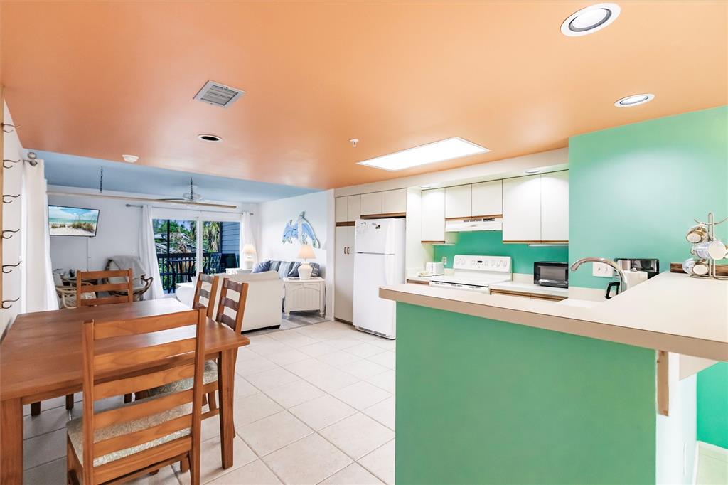 9200 Little Gasparilla, Unit 203 Placida, FL 33946 - Photo 13 of 41 a room with kitchen island a table and chairs in it