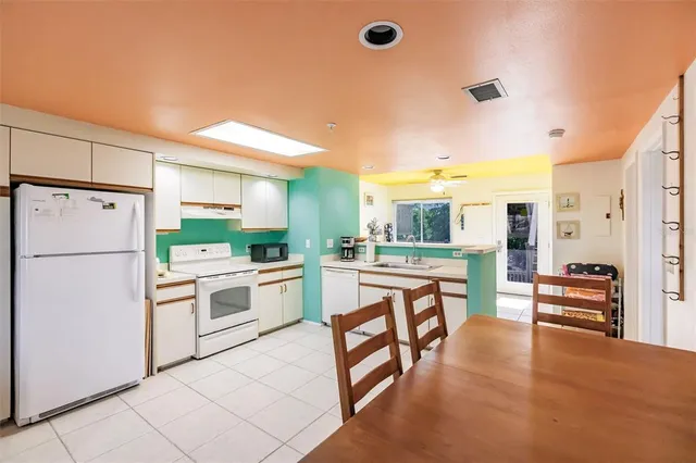 a kitchen with white cabinets and white appliances