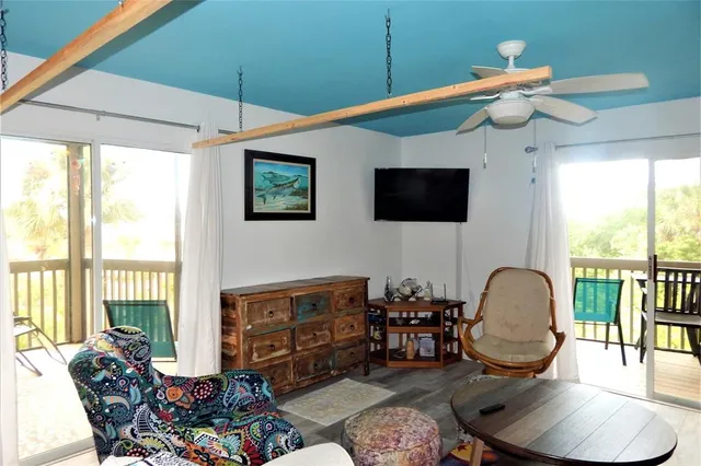 a living room with furniture a flat screen tv and a large window