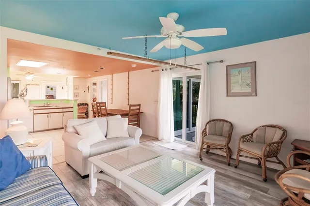 a living room with furniture kitchen view and a chandelier