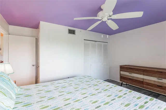 a bedroom with a bed and a ceiling fan
