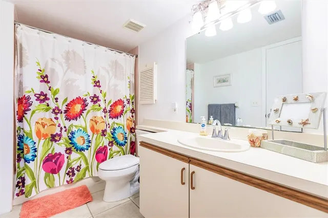 a bathroom with a sink a toilet and a curtain