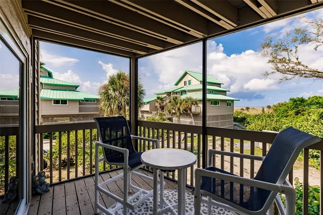a view of a chairs and table in patio with wooden floor
