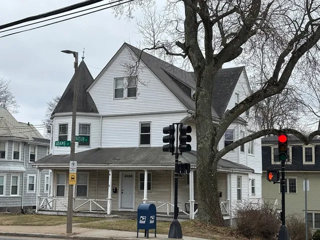 a front view of a house with a tree