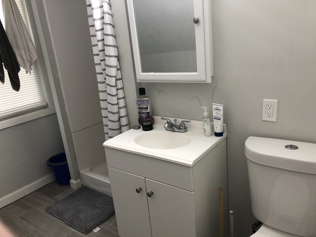 1122 Adams Street, Unit 2 Boston, MA 02124 - Photo 13 of 21 a bathroom with a sink a toilet and a mirror