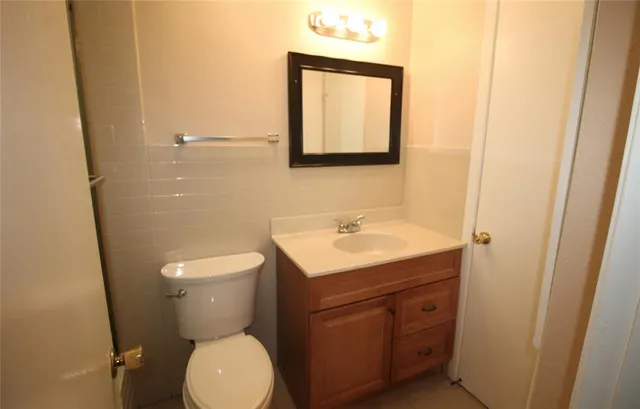 a bathroom with a toilet sink and mirror