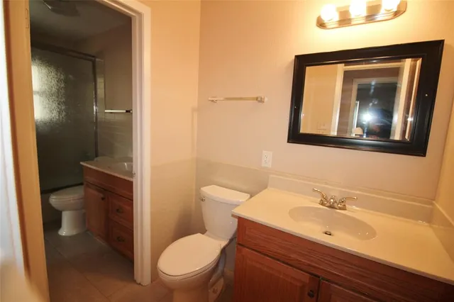 a bathroom with a toilet a sink and mirror