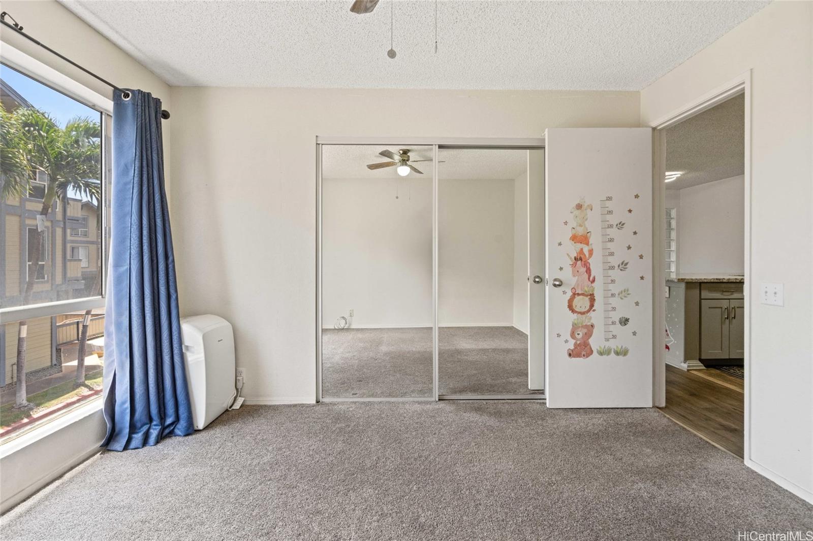 91-299 Hanapouli Circle, Unit 1C Ewa Beach, HI 96706 - Photo 16 of 25 an empty room with a fireplace and windows