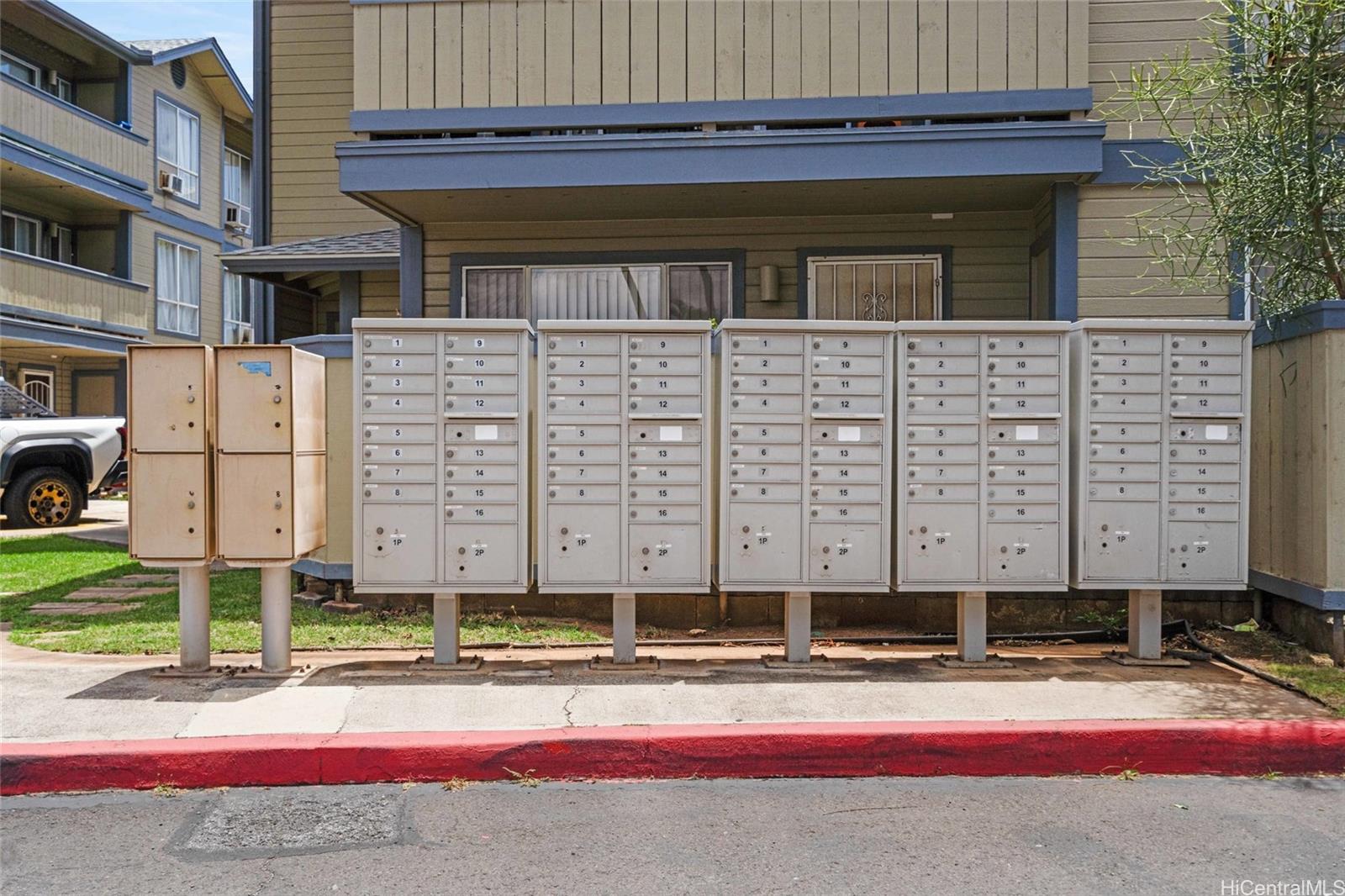 91-299 Hanapouli Circle, Unit 1C Ewa Beach, HI 96706 - Photo 24 of 25 a view of a brick house with large windows