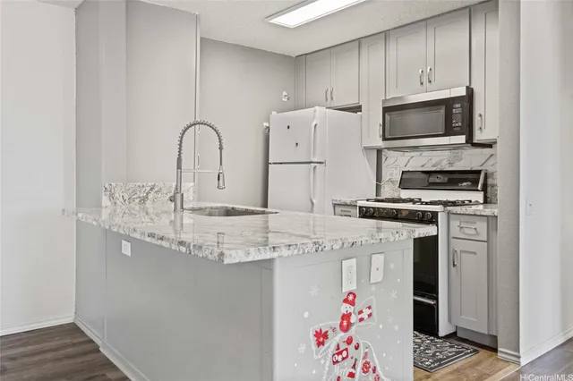 a kitchen with granite countertop a sink stainless steel appliances and cabinets